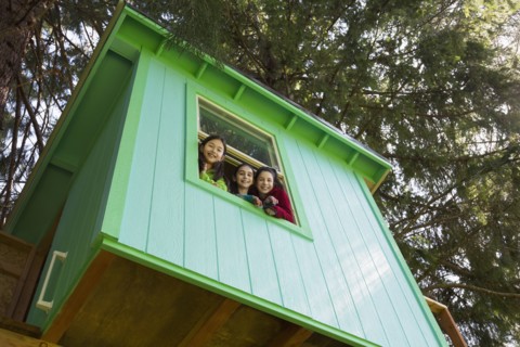 Girls leaning out tree house window