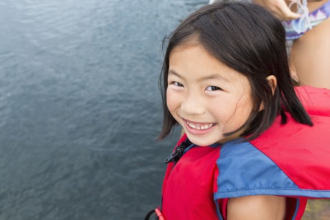 Mixed race girl smiling by lake
