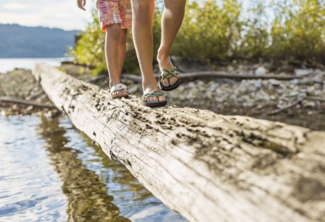 Mixed race children walking on log