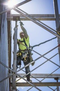 Caucasian worker on scaffolding on construction site
