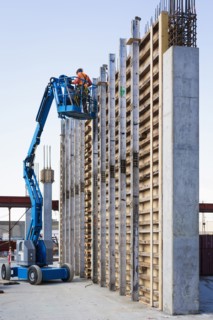 Caucasian worker on boom lift at construction site
