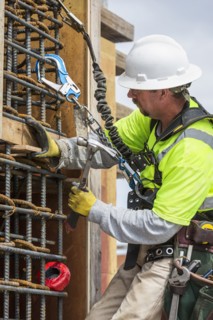 Caucasian worker examining wall at construction site