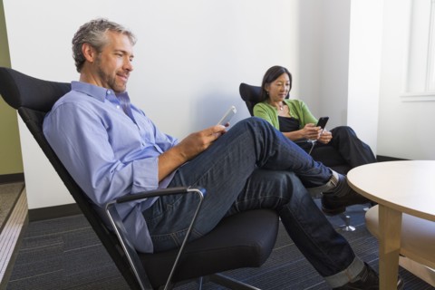 Business people using cell phones in office