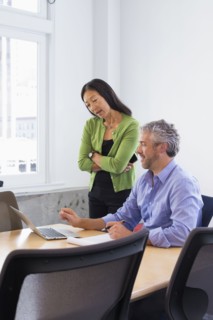 Business people working on laptop in conference room