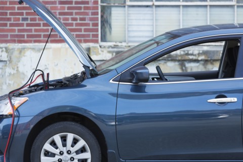Empty broken down car with jumper cables