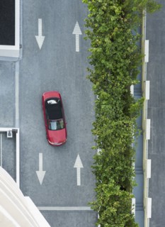 Aerial view of car driving on street with arrows