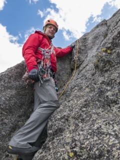 Caucasian climber using rope on rock