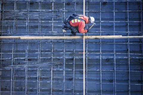 Caucasian worker nailing boards at construction site