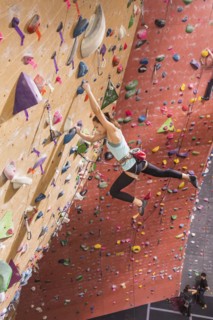Caucasian woman climbing rock wall