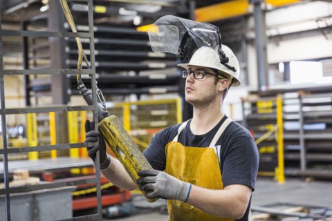 Caucasian worker holding controller in factory