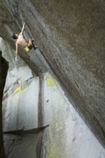 Mixed race boy rock climbing