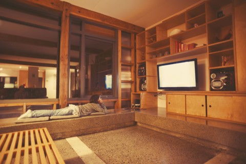 Mixed race girl watching television in modern living room