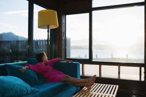 Mixed race girl looking out living room window