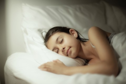 Mixed race girl sleeping on bed