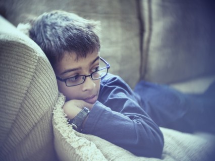 Mixed race boy laying on sofa