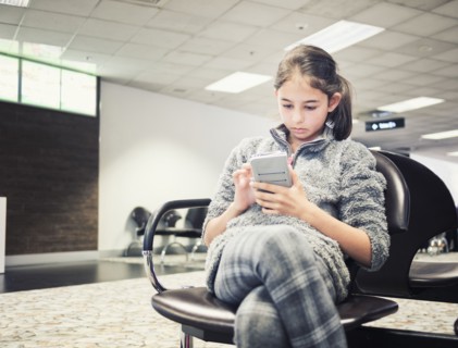 Mixed race girl using cell phone in airport