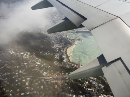 Aerial view of airplane wing flying over Wellington cityscape