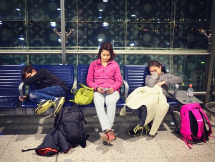 Mother and children relaxing in airport waiting area
