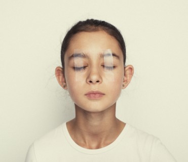 Mixed race girl with eyes taped shut