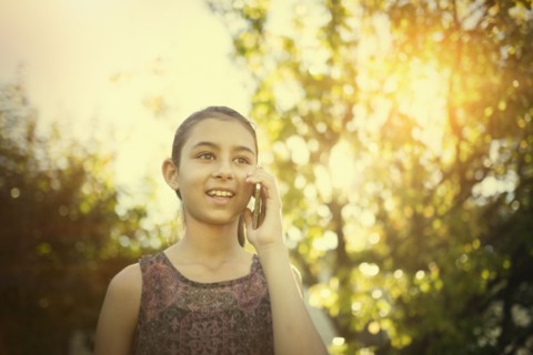 Mixed race girl talking on cell phone outdoors