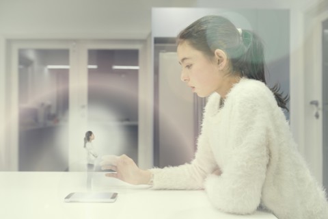 Mixed race girl examining hologram projection