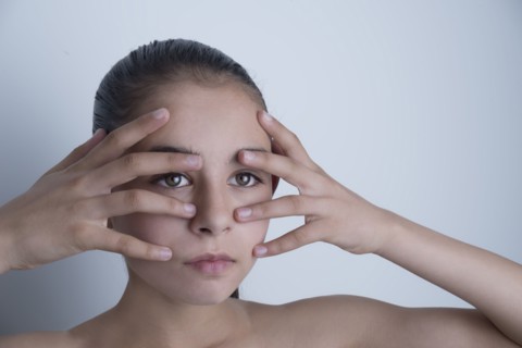 Mixed race girl touching her face