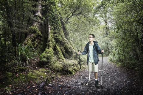 Mixed race boy hiking in forest