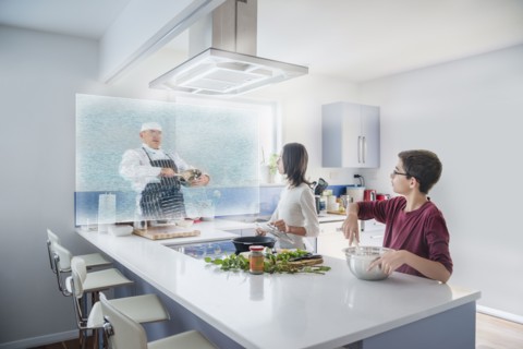 Brother and sister watching hologram cooking show in kitchen