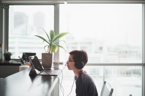 Mixed race boy listening to headphones in kitchen