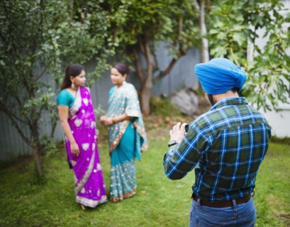 Man photographing women in traditional Indian dresses