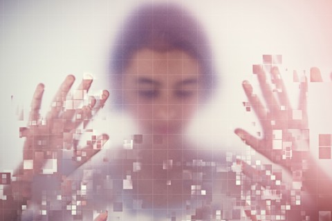 Mixed race girl standing behind pixelated screen