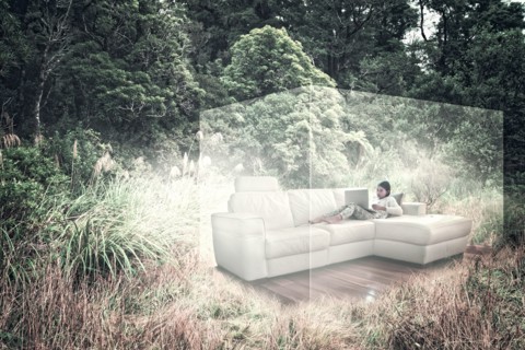 Mixed Race girl using laptop on sofa in virtual cube