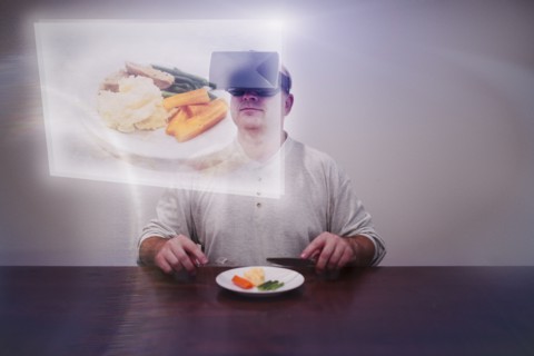 Caucasian man imagining larger meal with VR goggles