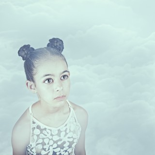 Wide-eyed Mixed Race girl in clouds