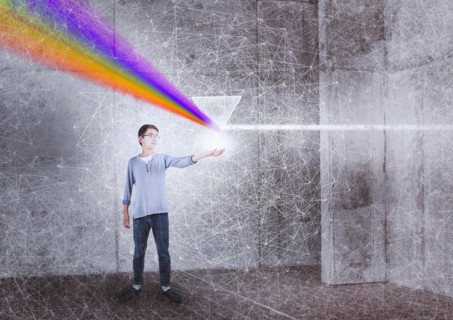 Mixed Race boy holding prism