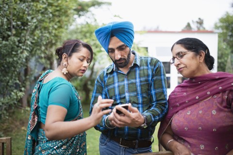 Family texting on cell phone outdoors