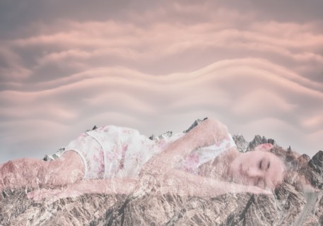 Double exposure of Mixed Race girl laying on mountain landscape