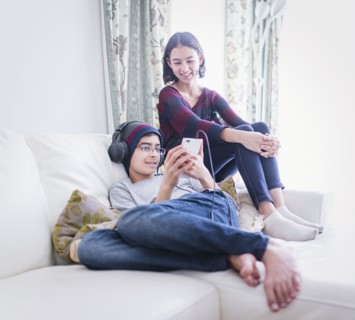 Mixed Race brother and sister watching cell phone