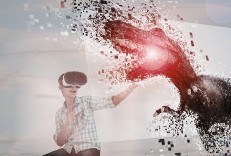 Mixed Race boy using virtual reality goggles watching dinosaur