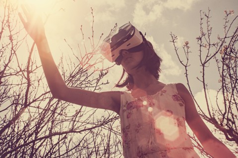 Mixed Race girl using virtual reality goggles outdoors