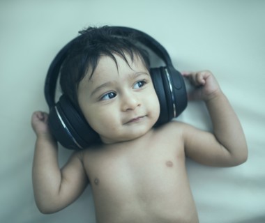 Indian baby boy listening to headphones