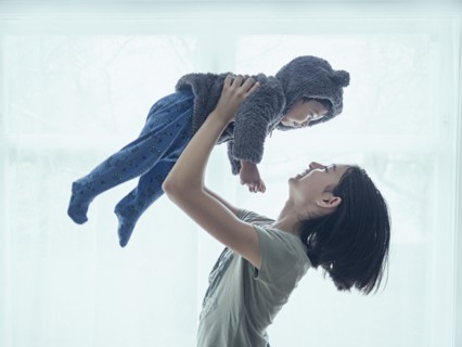 Sister lifting baby brother