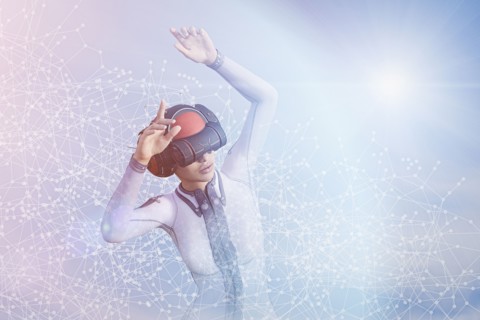 Woman with arms raised using virtual reality helmet