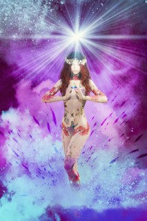 Naked woman with tattoos standing in purple and blue glowing sky