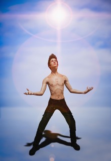 Shirtless man looking at glowing sky