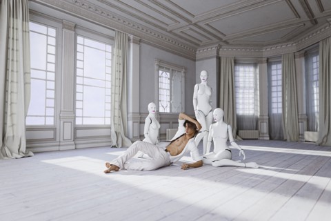 Man sitting on floor with women robots