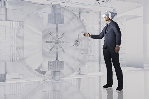 Businessman near vault wearing virtual reality goggles