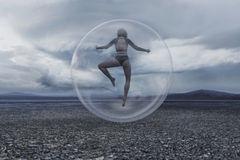 Woman floating in sphere in remote landscape