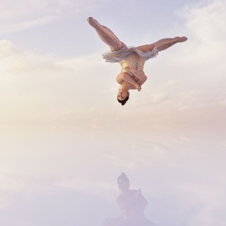 Woman wearing corset and boots upside-down in clouds