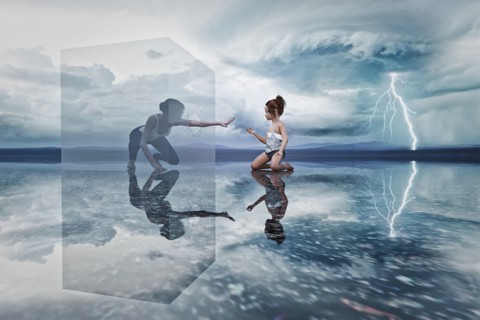 Woman in cube reaching to kneeling girl